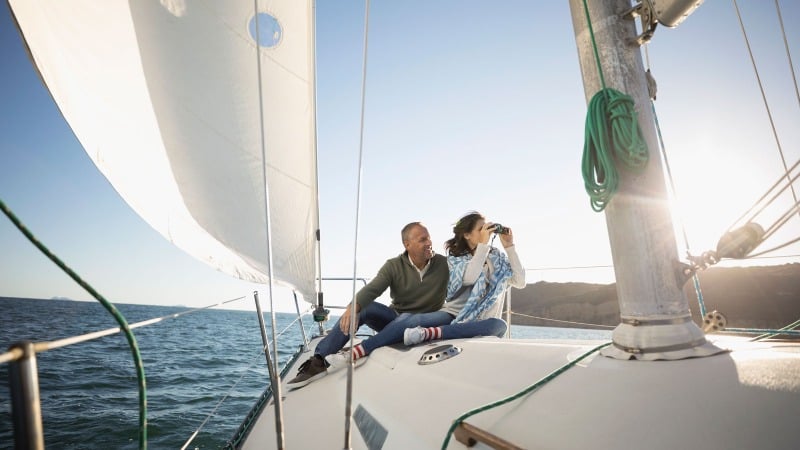 A man and a woman enjoying traveling by yacht